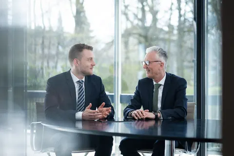 Zwei Männer im Anzug bei einer Besprechung