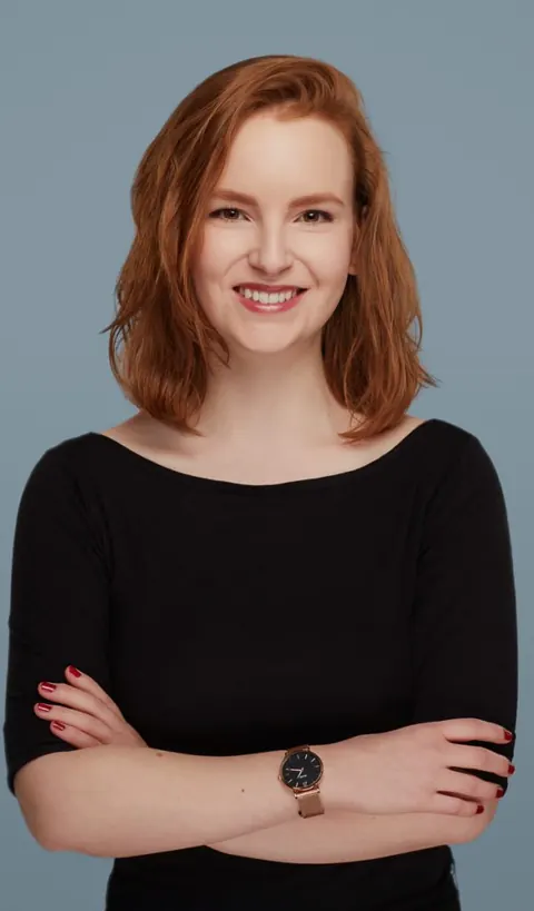 Frau mit roten Haaren vor grauem Hintergrund
