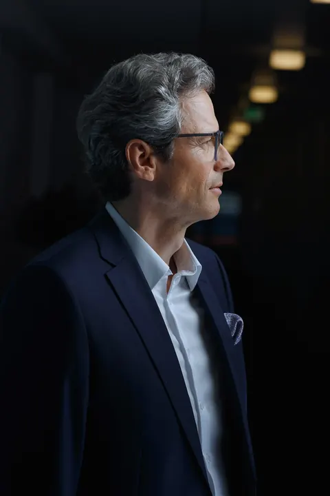 Mann mit Brille im Profil vor dunklem Hintergrund
