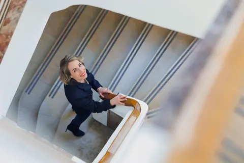 Frau im Treppenhaus, von oben fotografiert